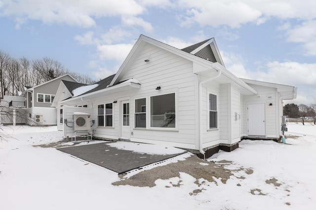 snow covered property with ac unit