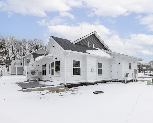 snow covered house with ac unit