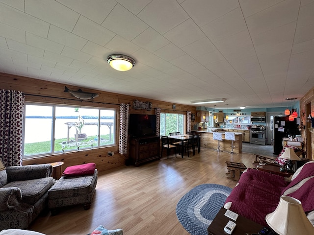 living room featuring light hardwood / wood-style floors and wood walls