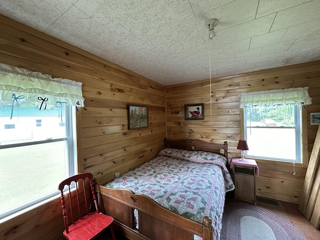 bedroom featuring wooden walls