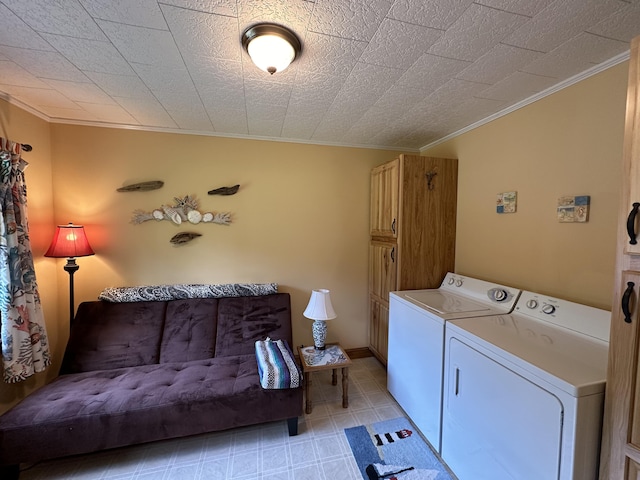 laundry room with cabinets, washing machine and clothes dryer, and ornamental molding