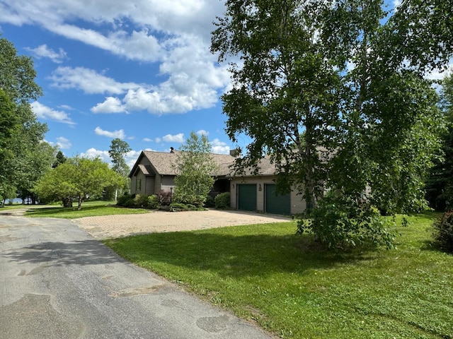 view of front of home with a garage and a front lawn