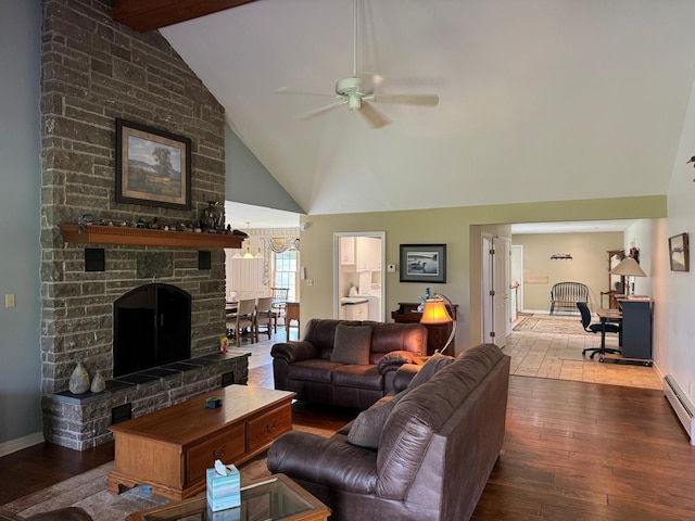 living room with ceiling fan, beam ceiling, a stone fireplace, hardwood / wood-style floors, and high vaulted ceiling