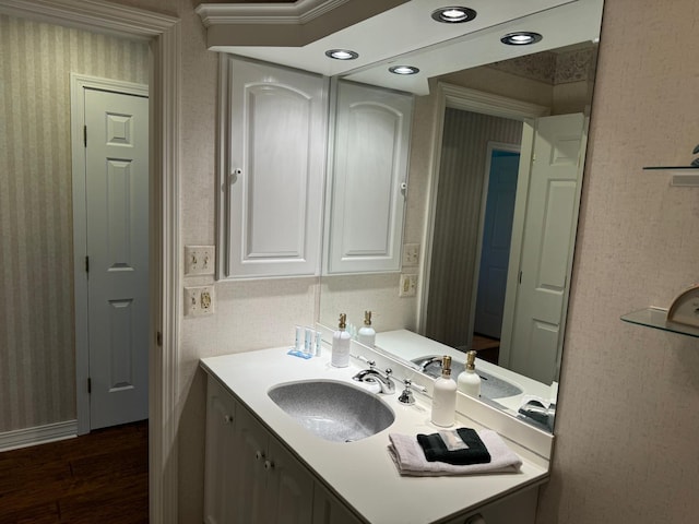 bathroom with vanity, hardwood / wood-style flooring, and ornamental molding