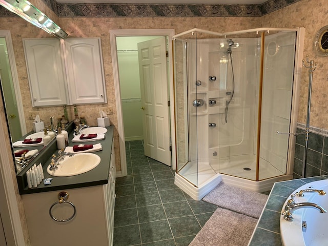 bathroom with tile patterned flooring, walk in shower, and vanity