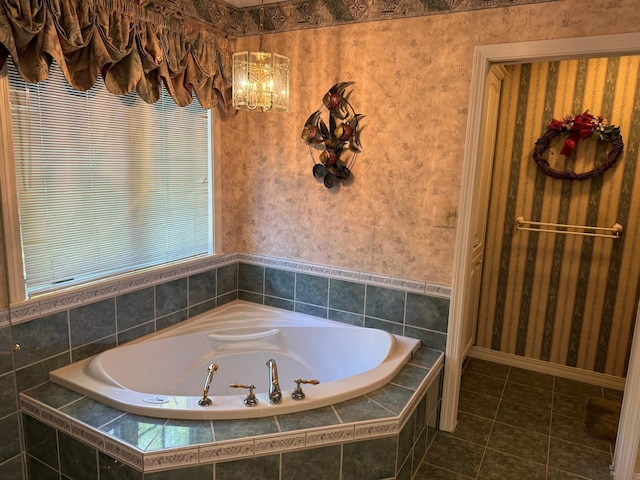 bathroom featuring tiled tub, tile patterned floors, and a notable chandelier