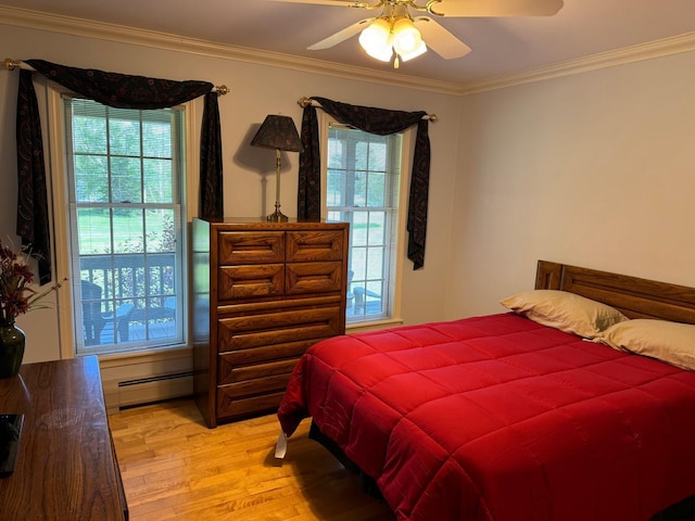 bedroom with ceiling fan, baseboard heating, multiple windows, and light wood-type flooring