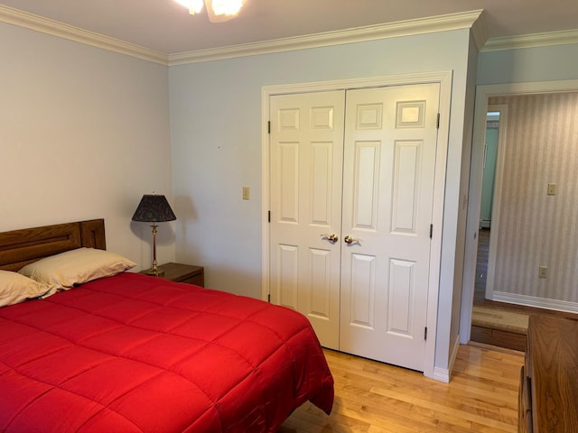 bedroom with light hardwood / wood-style floors, a closet, and crown molding