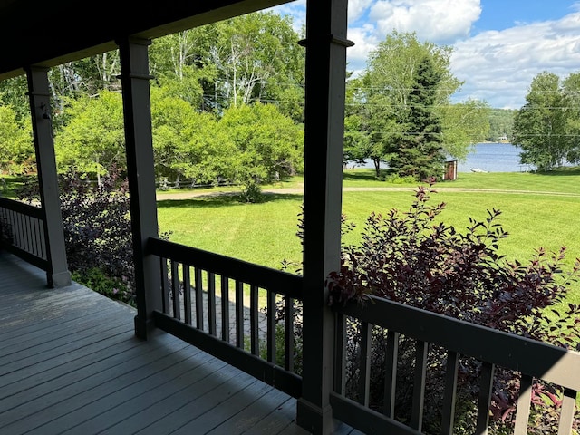 wooden terrace with a yard and a water view