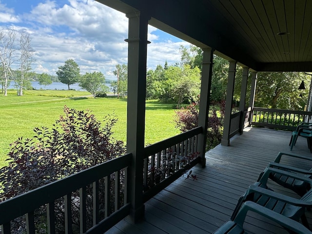 wooden terrace featuring a porch, a water view, and a yard