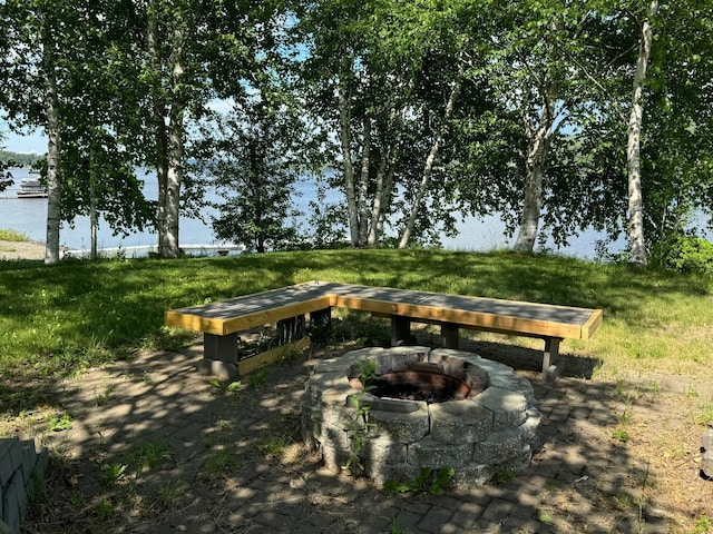 view of property's community with an outdoor fire pit and a water view