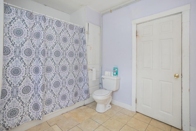 bathroom featuring tile patterned flooring, curtained shower, and toilet