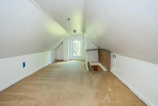 additional living space with light colored carpet and lofted ceiling