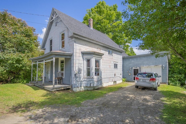 view of front of house featuring a porch, a garage, a front yard, and cooling unit