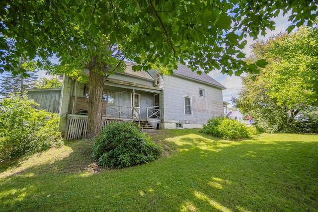 back of house with a lawn and covered porch