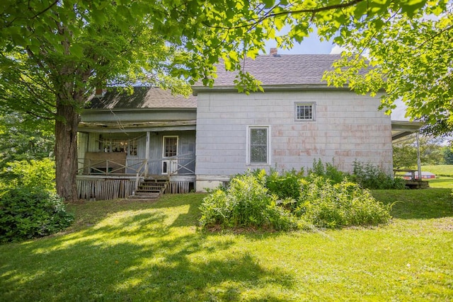 rear view of house featuring a lawn