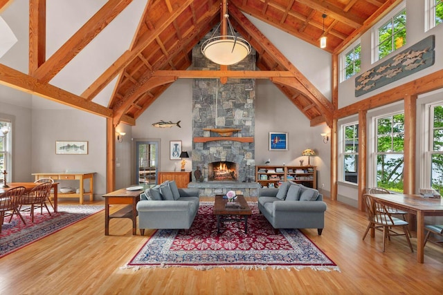 living room with high vaulted ceiling, a fireplace, and hardwood / wood-style flooring