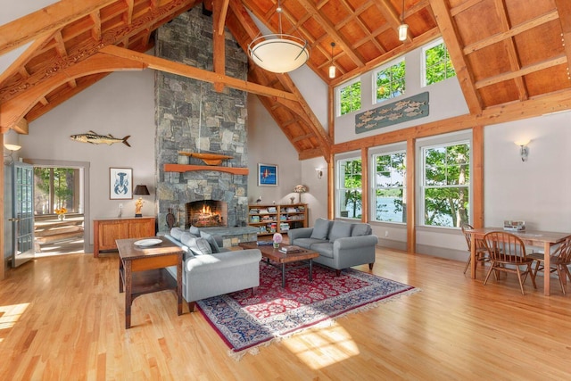 living room with high vaulted ceiling, light hardwood / wood-style flooring, and a fireplace