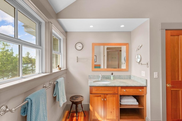 bathroom with an enclosed shower, vanity, and lofted ceiling