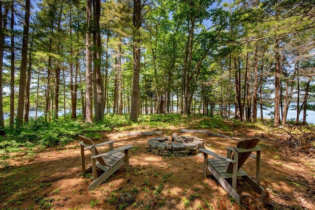 view of yard featuring an outdoor fire pit and a water view