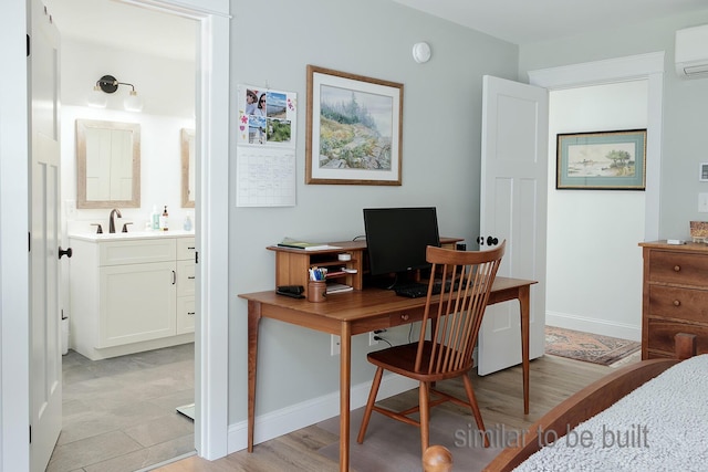 office featuring light hardwood / wood-style flooring, sink, and a wall mounted air conditioner