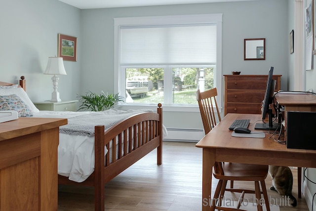 bedroom featuring baseboard heating and light hardwood / wood-style floors