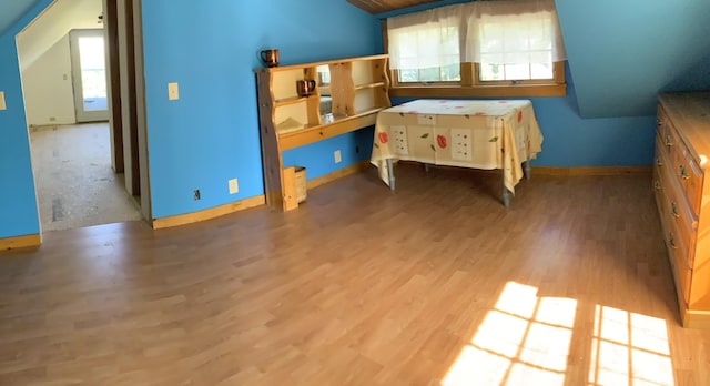 unfurnished bedroom featuring lofted ceiling and wood-type flooring