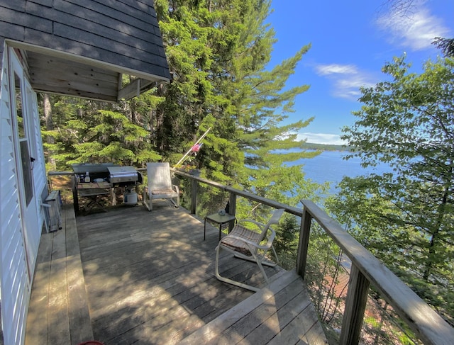 wooden deck featuring a grill and a water view