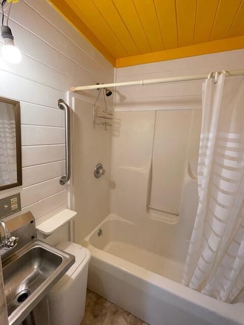 full bathroom with toilet, shower / tub combo, sink, wooden walls, and wooden ceiling