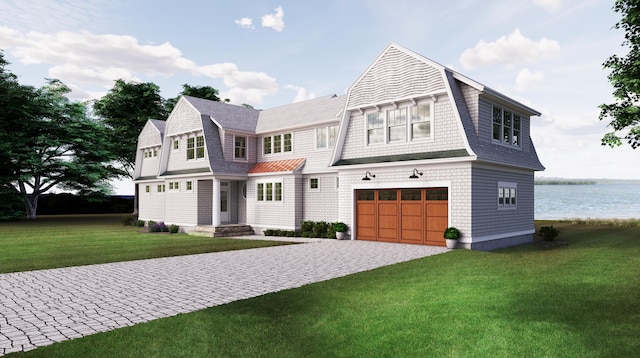 shingle-style home featuring a garage, a front yard, a gambrel roof, and decorative driveway