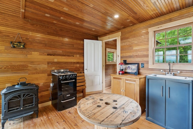 kitchen featuring wood counters, light hardwood / wood-style flooring, wood walls, and sink