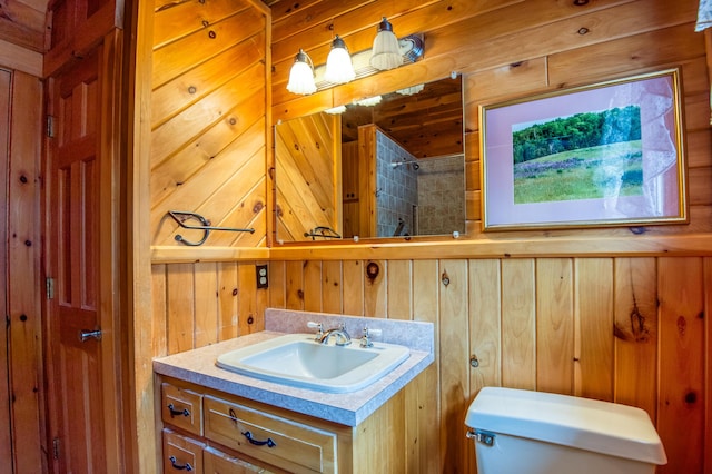 bathroom featuring vanity, a shower, toilet, and wood walls