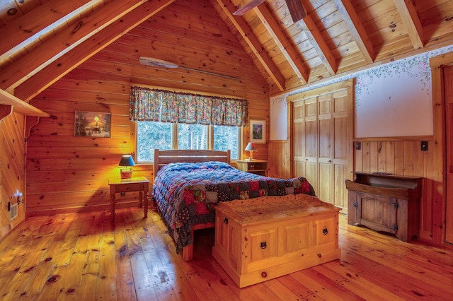 bedroom featuring lofted ceiling with beams, wooden ceiling, light hardwood / wood-style floors, and wood walls