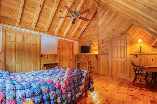 bedroom with wood walls, lofted ceiling with beams, light wood-type flooring, wooden ceiling, and ceiling fan