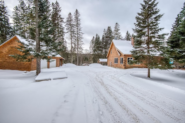 snowy yard featuring a garage