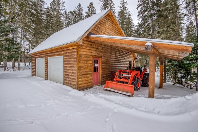 snow covered garage with a carport