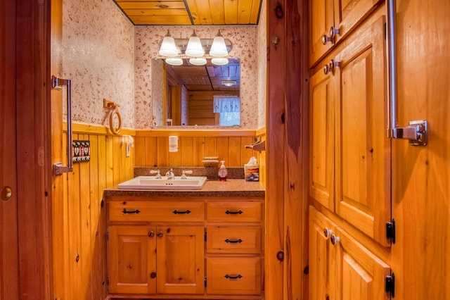 bathroom featuring vanity, wood ceiling, and wood walls