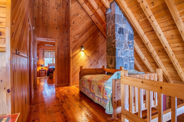 unfurnished bedroom featuring wood ceiling, beam ceiling, high vaulted ceiling, wood-type flooring, and wood walls