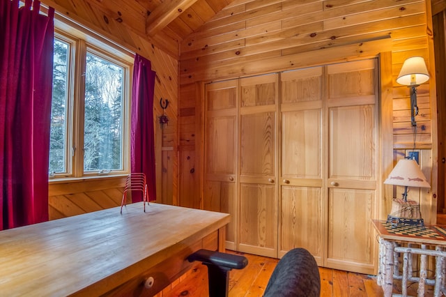 office space featuring wood ceiling, wood walls, light hardwood / wood-style floors, and vaulted ceiling with beams