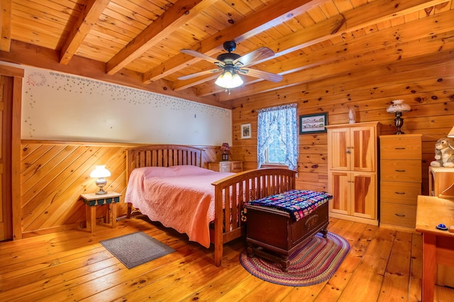 bedroom with wood walls, wooden ceiling, beam ceiling, and light wood-type flooring