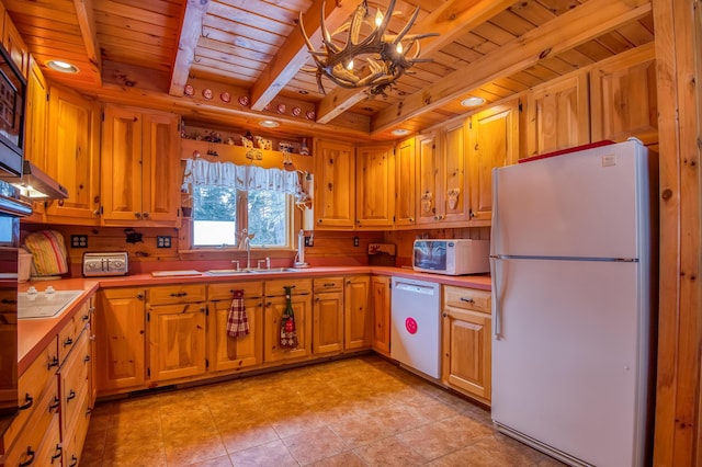 kitchen featuring white appliances, sink, hanging light fixtures, and wooden ceiling