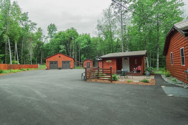 log-style house with a garage and an outbuilding