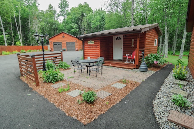 view of patio with a garage and an outbuilding