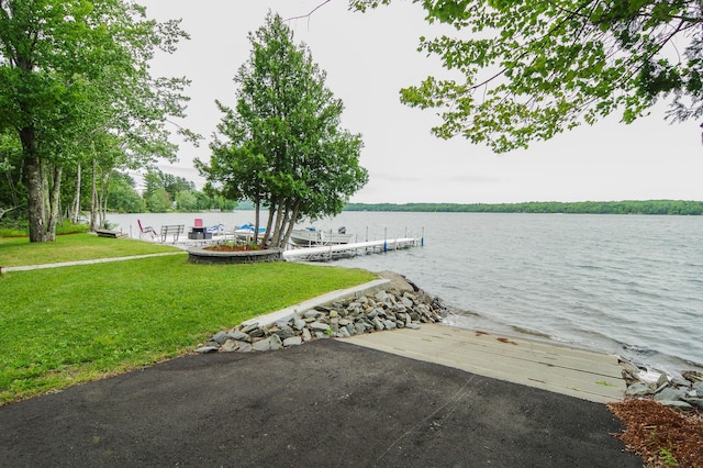 view of dock featuring a yard and a water view