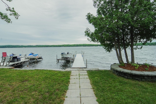 view of dock featuring a water view and a yard