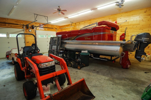 garage featuring ceiling fan and wood walls