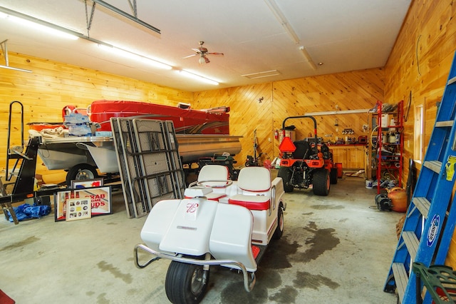 garage featuring ceiling fan and wood walls