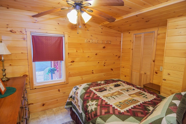 bedroom with ceiling fan, a closet, wood ceiling, and wooden walls