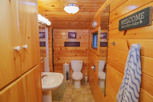 bathroom with toilet, wood ceiling, wooden walls, lofted ceiling, and sink