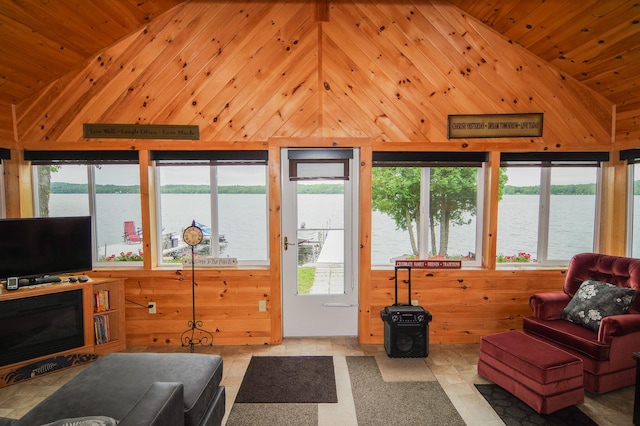 living room with a water view, a fireplace, wood ceiling, and wooden walls